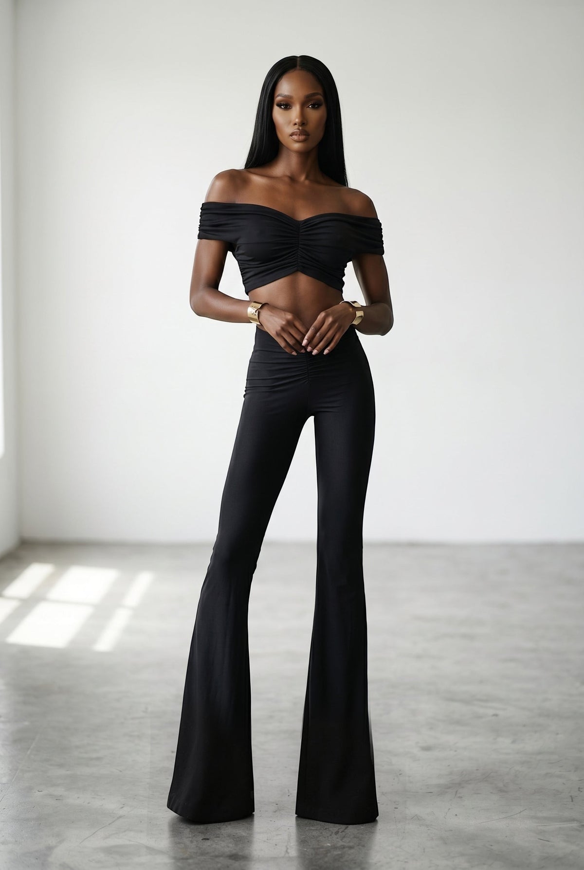 The Saint 54 black off-shoulder crop top and wide leg pants set with ruched detailing on a model.